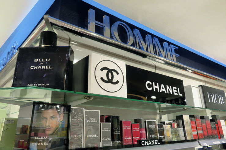 Signalétique en lettres découpées du rayon parfums Homme au-dessus des produits
